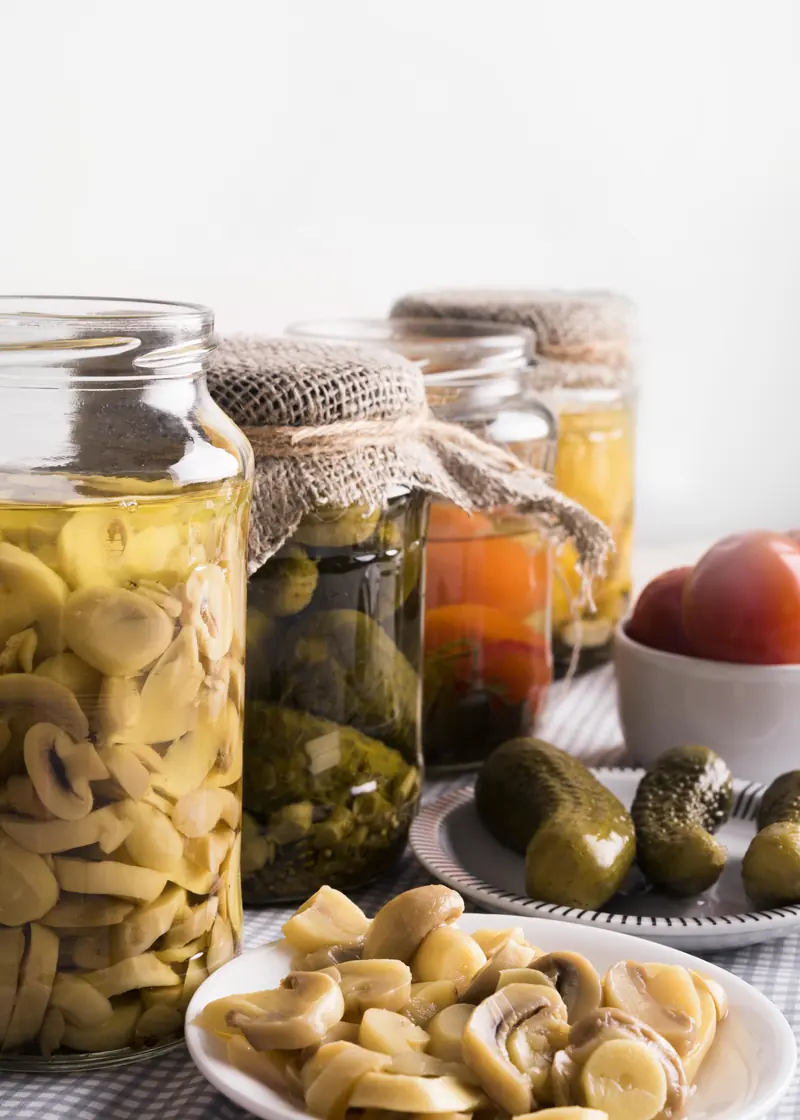 Tarros de cristal con champiñones, pepinillos y tomates en conserva
